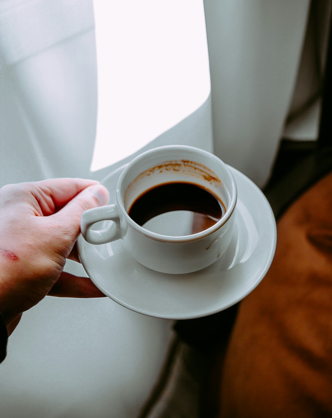 person-holding-white-ceramic-mug-with-black-liquid-vcpa0zgdkse